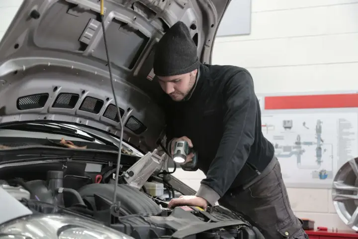 Mechanik bada silnik, szukając objawów uszkodzenia przegubu zewnętrznego.