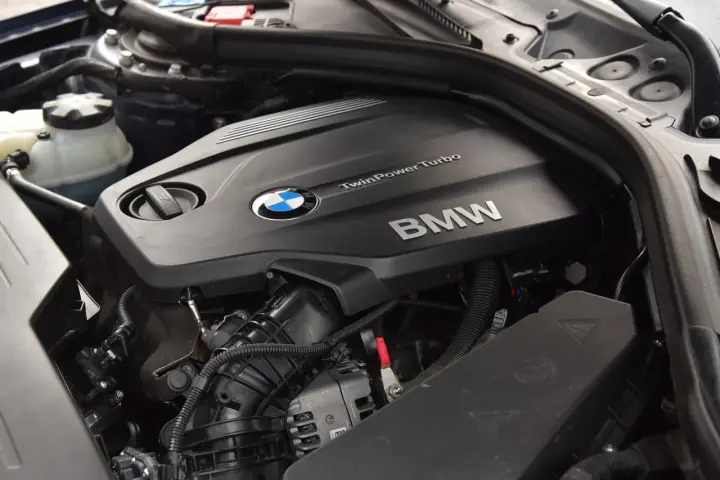 Silnik BMW TwinPower Turbo, prawdopodobnie 2.0 diesel, z widocznym logo BMW i elementami osprzętu.