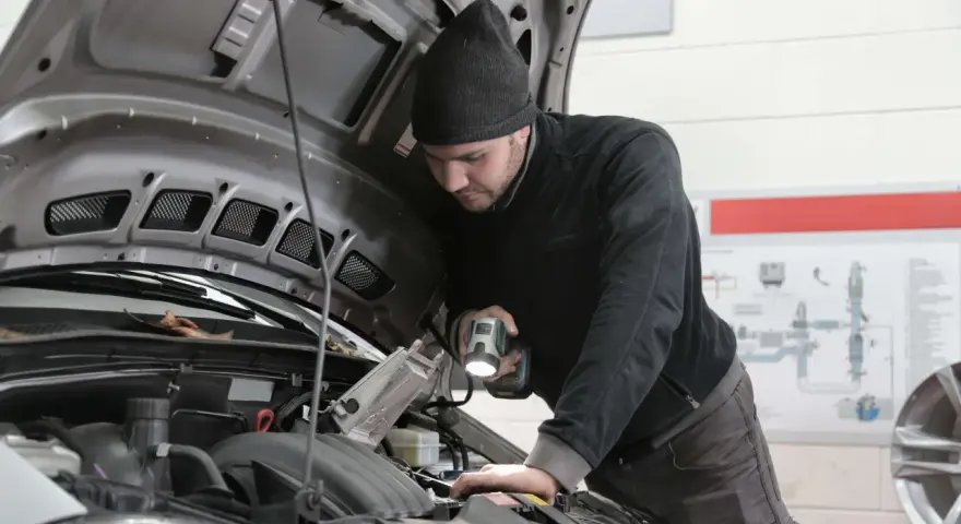 Mechanik bada silnik, szukając objawów uszkodzenia przegubu zewnętrznego.