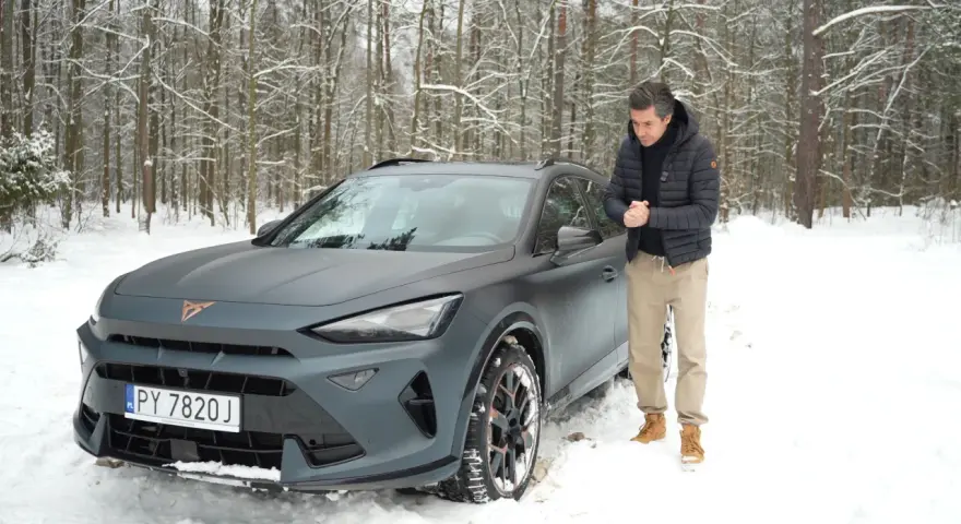 Mężczyzna obok matowego, szarego Formentor Cupra w zimowym lesie.