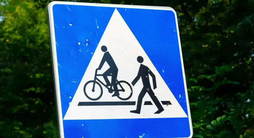 Znak ostrzegawczy: przejazd rowerowy i przejście dla pieszych. Czy rowerzysta ma pierwszeństwo na przejeździe rowerowym? Tak, ten znak informuje o tym.