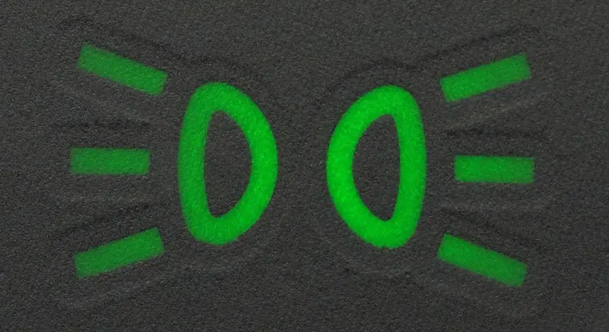 Zielony symbol świateł mijania na ciemnym tle.