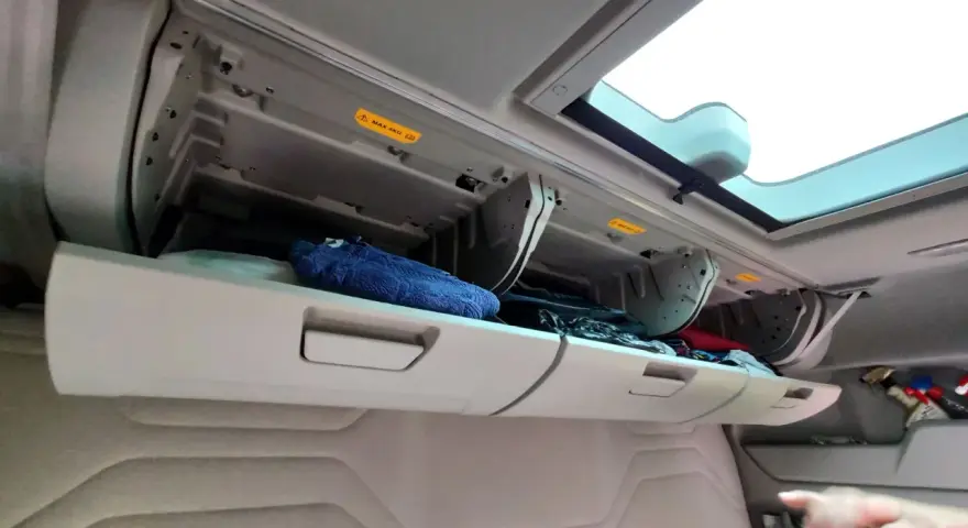 Schowek w kabinie Ford F-Max z niebieskim ręcznikiem i innymi przedmiotami.