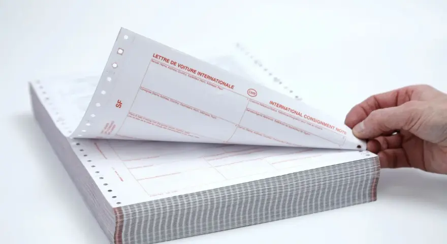 Stos papierów z nadrukiem "CMR" i "INTERNATIONAL CONSIGNMENT NOTE". Dokumenty te służą do międzynarodowego przewozu towarów.