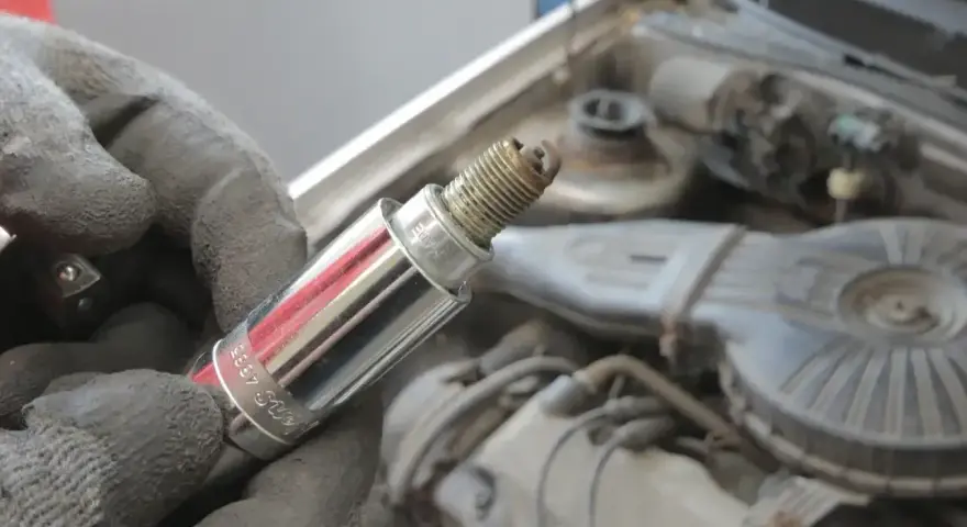 Rękawica trzyma świecę zapłonową, potencjalną przyczynę błędu dtc p0300 w Renault.