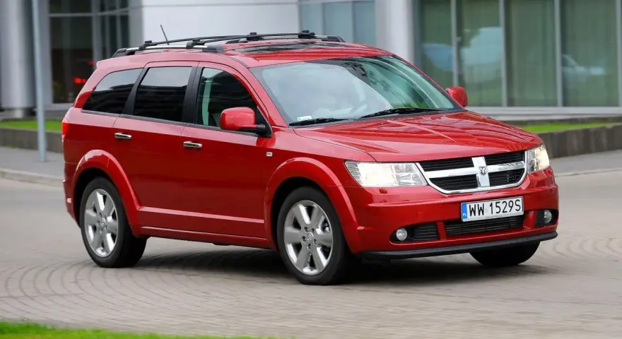 Czerwony Dodge Journey w ruchu. Wiele osób szuka dodge journey opinie przed zakupem.