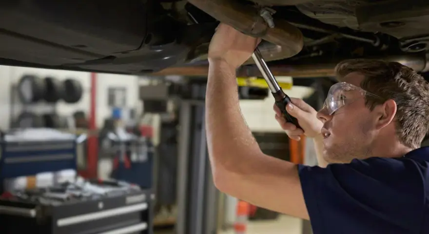 Mechanik naprawia układ wydechowy Renault, być może z powodu błędu DTC P0420.