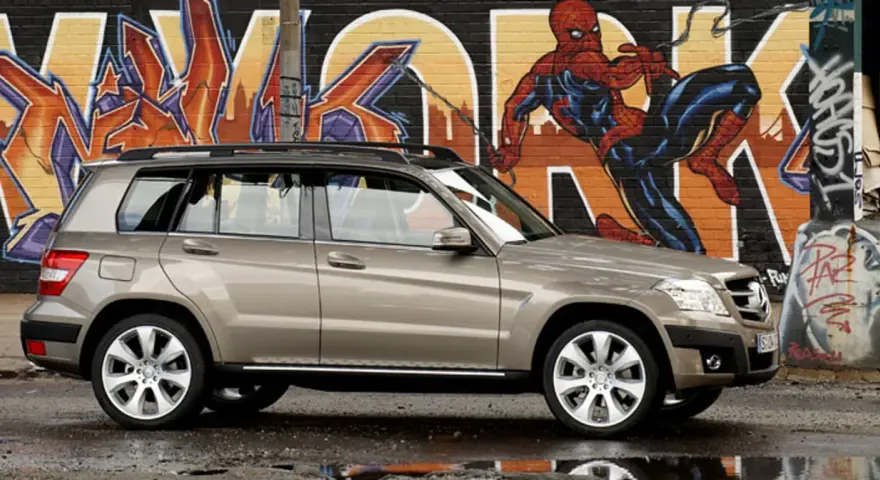 Brązowy suv Mercedes GLK na tle kolorowego graffiti z Spider-Manem.
