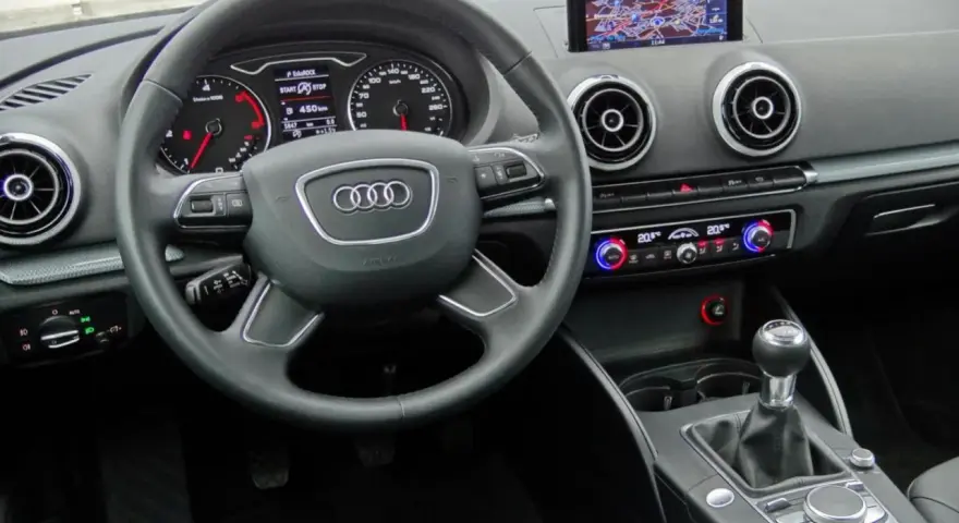 Wnętrze Audi A3 kombi: kierownica, nawigacja, panel klimatyzacji i skrzynia biegów.