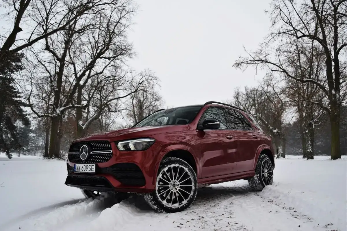 Czerwony Mercedes 4x4 w zimowym krajobrazie, gotowy na śnieżne wyzwania.