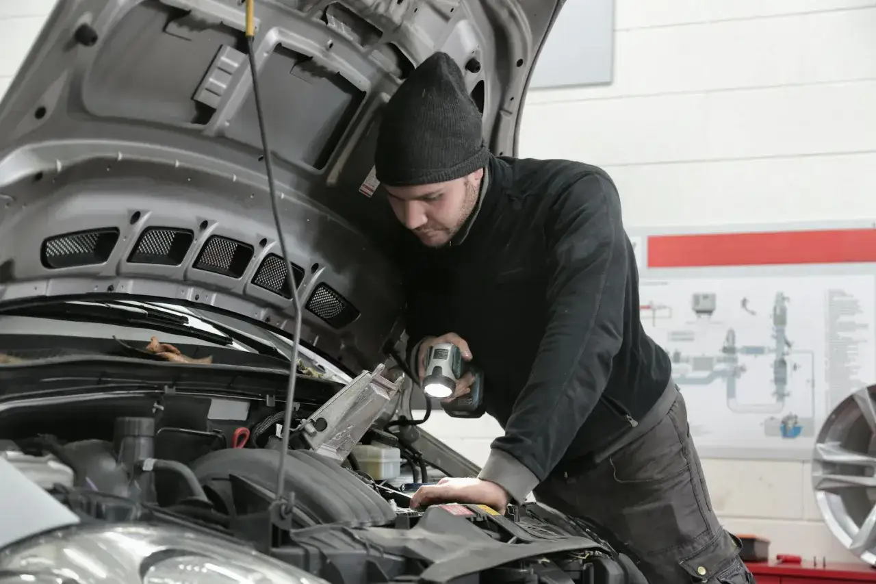 Mechanik z latarką bada silnik 1.9 TDI.