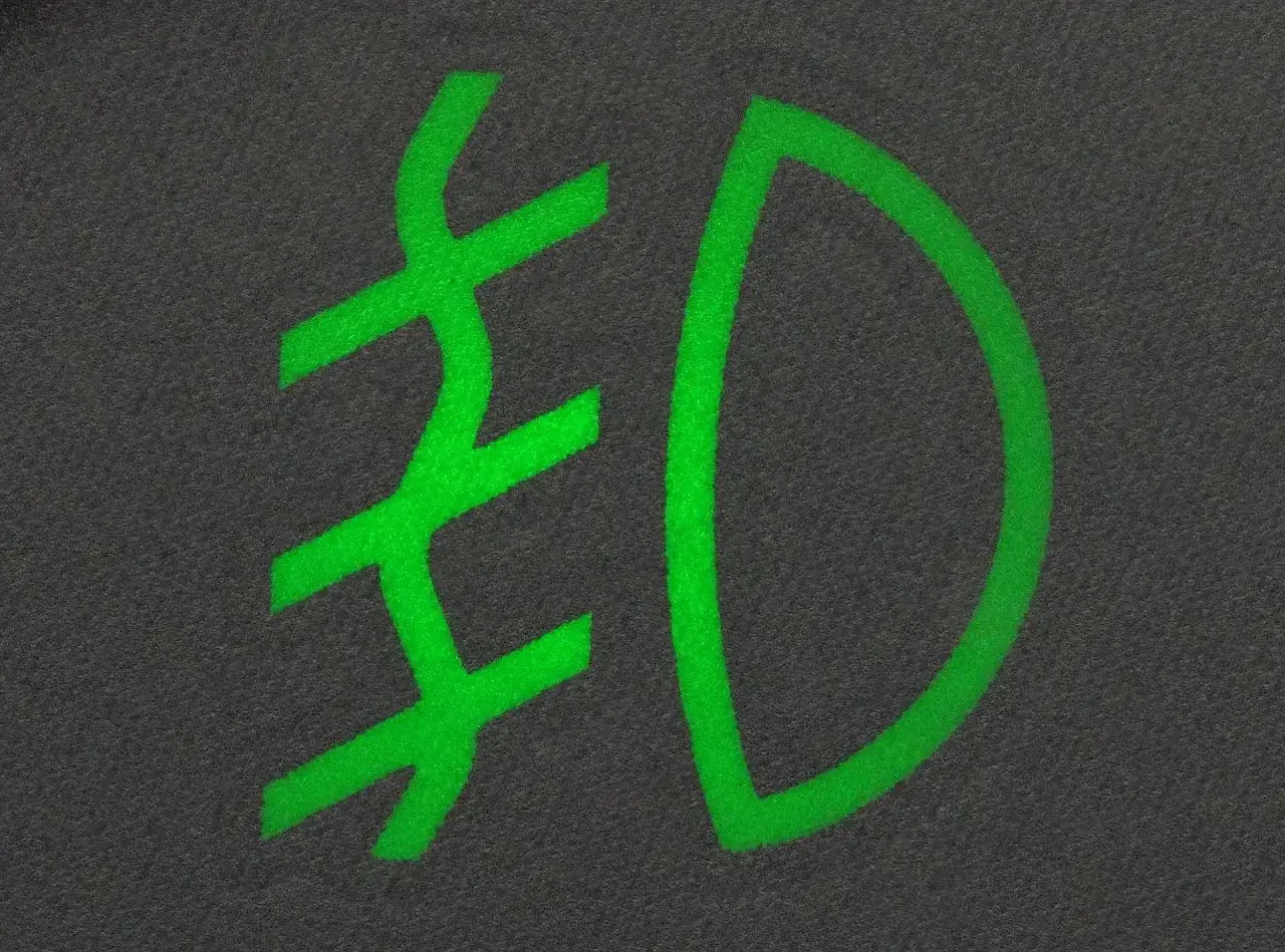Zielony symbol świateł mijania na ciemnym tle.