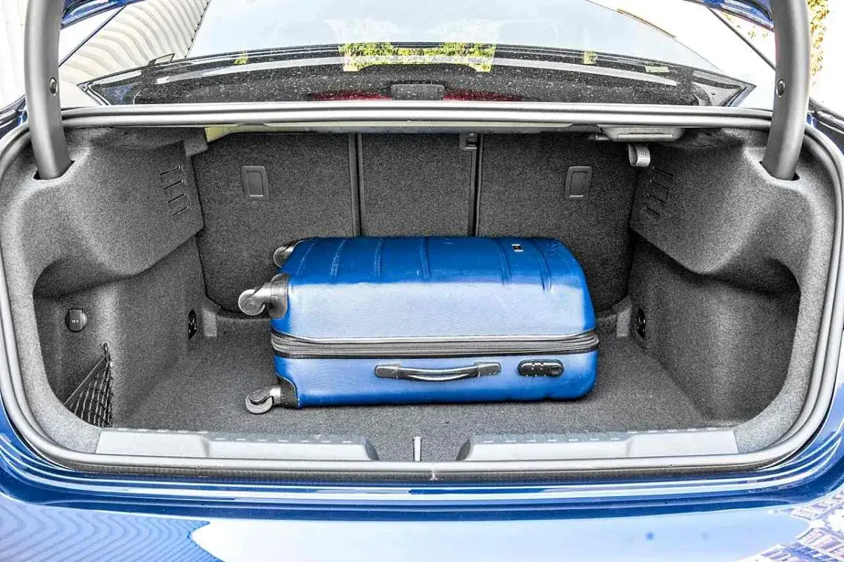 Bagażnik Audi A3 kombi gotowy na podróż. W środku zmieści się niebieska walizka.