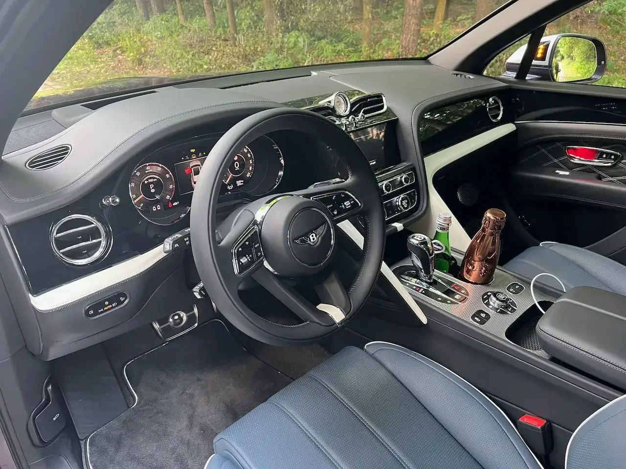 Wnętrze Bentley Bentayga. Luksusowe detale, skórzana tapicerka i napoje w uchwytach. Sprawdź Bentley Bentayga cena.