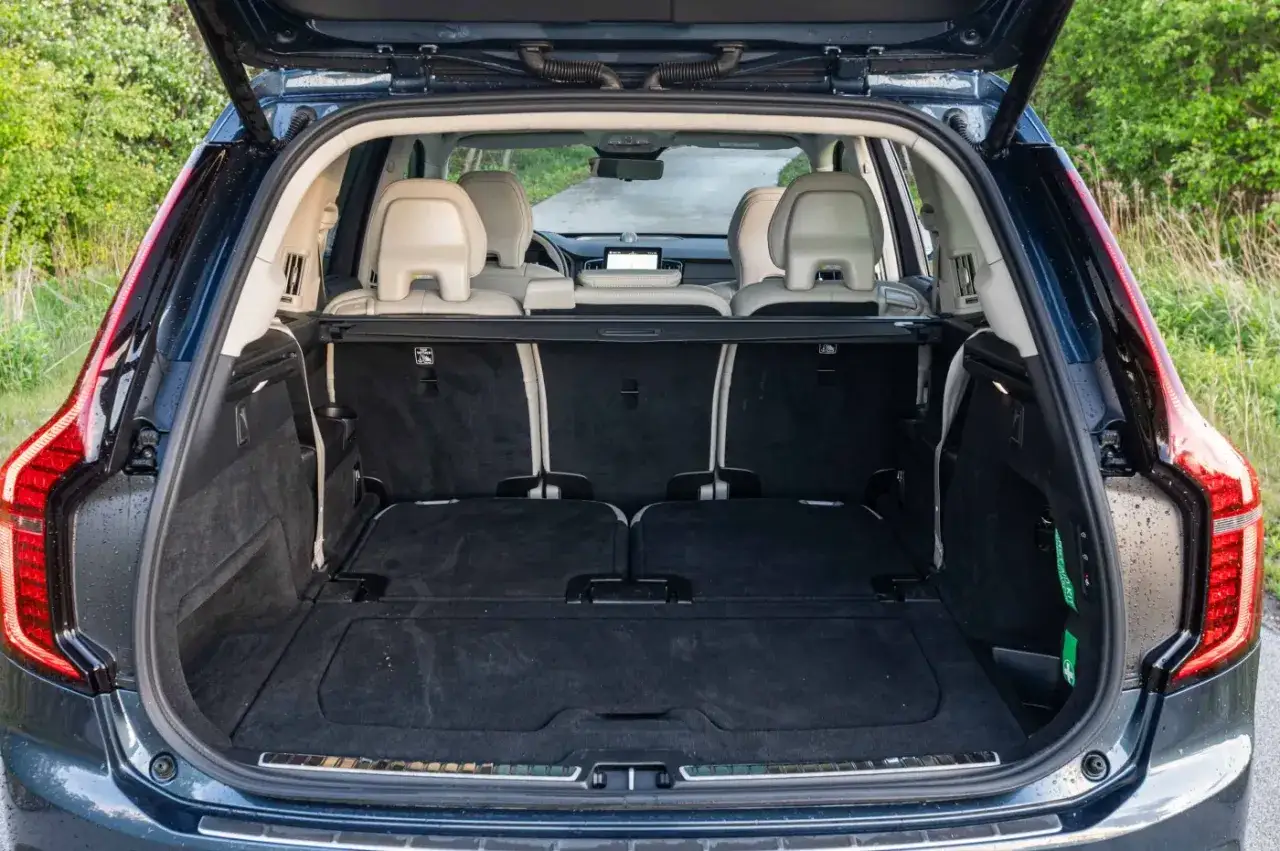 Wnętrze Volvo XC90 z otwartym bagażnikiem. Widoczne rozłożone fotele i przestronna przestrzeń bagażowa.