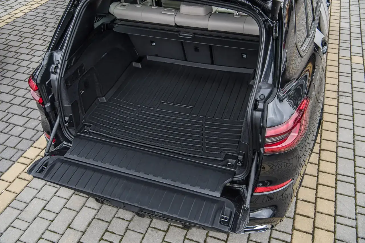 Bagażnik czarnego x5 bmw z gumową matą. Idealny na podróże z rodziną.