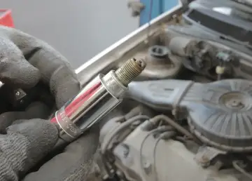 Rękawica trzyma świecę zapłonową, potencjalną przyczynę błędu dtc p0300 w Renault.
