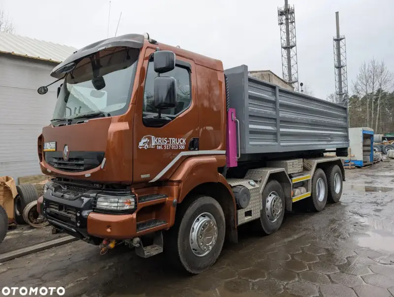 Brązowy Renault Kerax z naczepą wywrotką, gotowy do pracy na placu budowy.