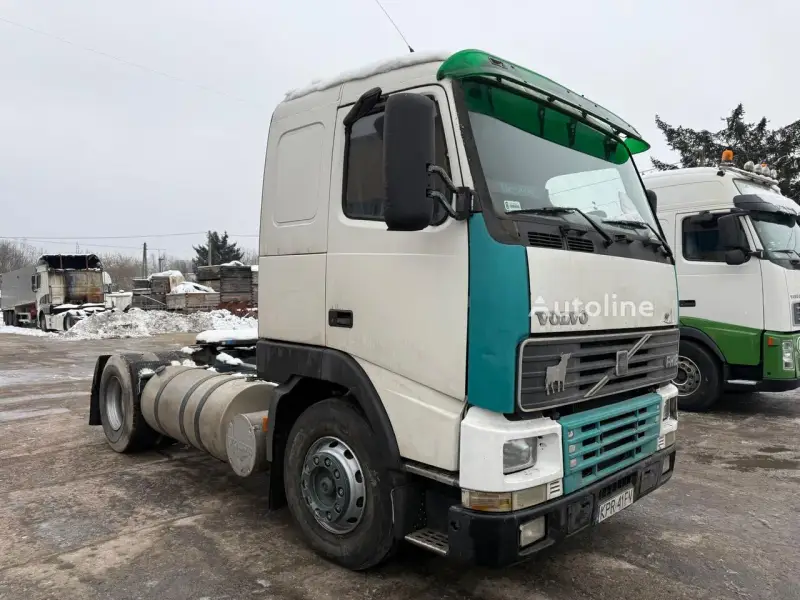 Ciężarówka Volvo FH12 z zielonym akcentem na kabinie, zaparkowana na zewnątrz w zimowy dzień.